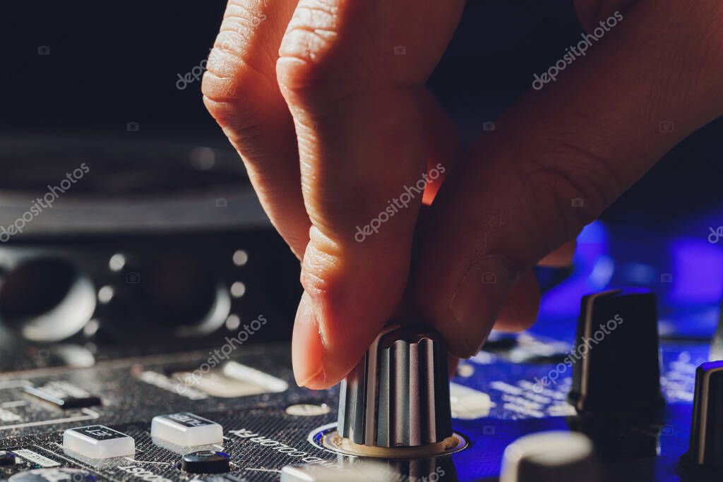 Music producer performing an electronic set with colorful lights