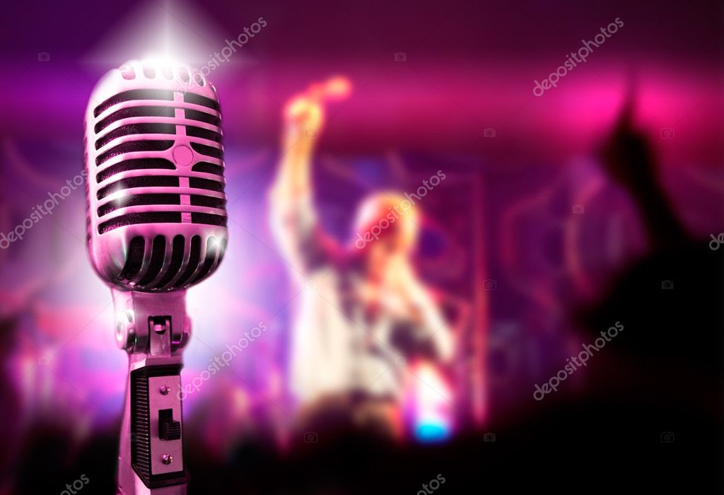 Singer performing on stage under warm yellow lights