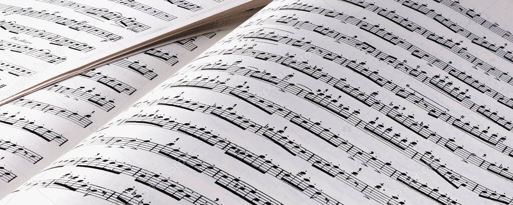 Composer at a piano writing music on a score