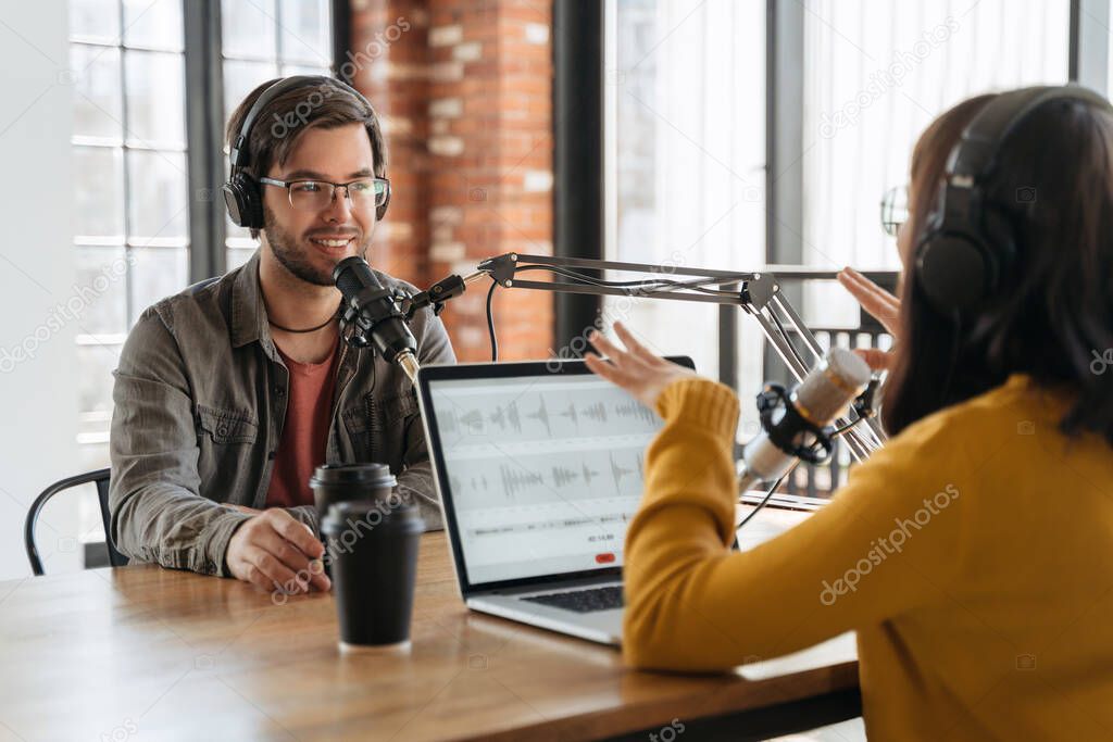 Podcast host speaking into a microphone with headphones on