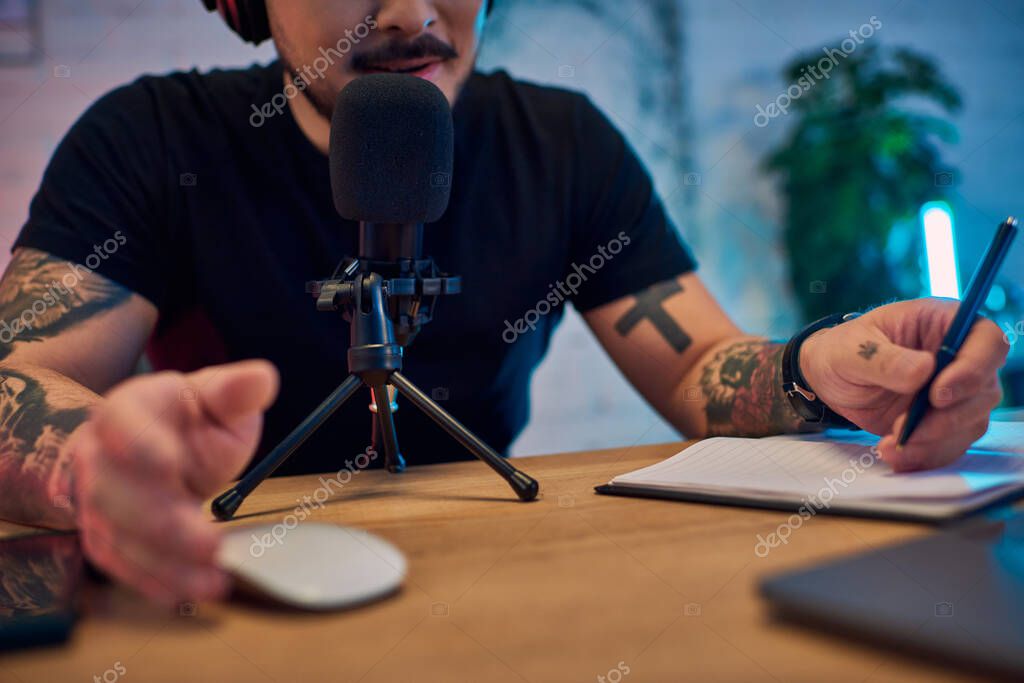 Podcast host speaking into a microphone in a recording setup