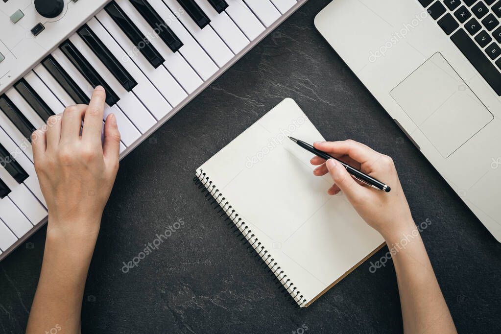Composer playing piano while recording an instrumental track