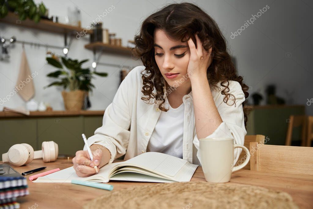 Open notebook with handwritten notes beside a cup of coffee