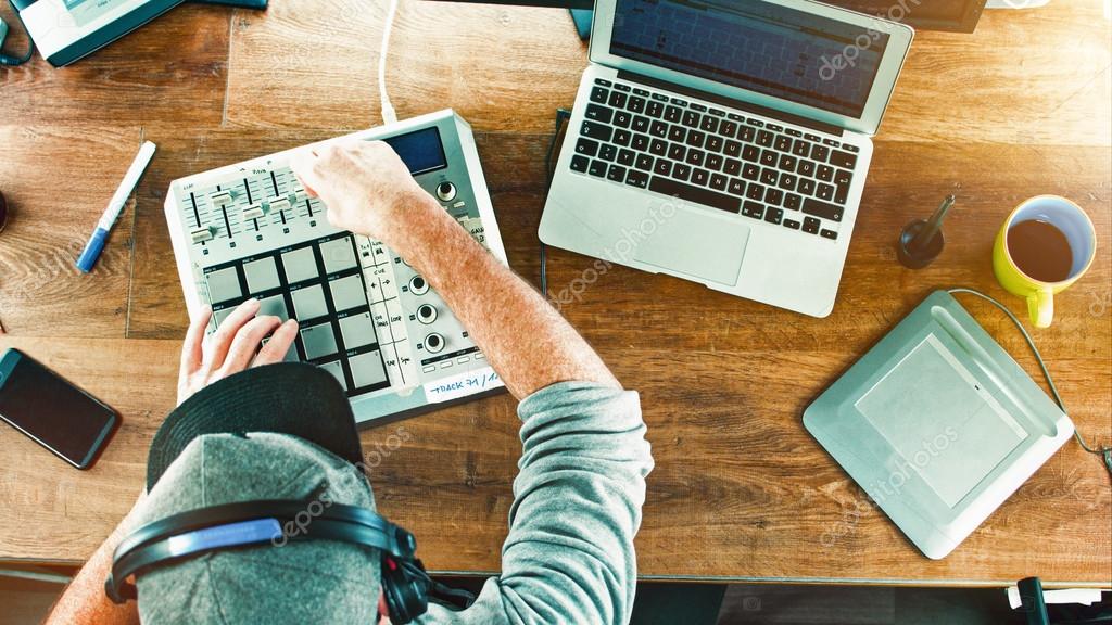 Music producer creating electronic beats on a laptop with headphones